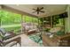 Relaxing screened porch with comfortable seating, ceiling fan, and scenic backyard views at 3500 Maple Wood Dr, Denver, NC 28037