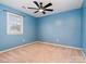 Cozy blue bedroom featuring a window, ceiling fan, and neutral carpet at 3572 Heather Ln, Gastonia, NC 28056