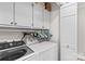 Organized laundry room with washer, dryer, storage cabinets, and hanging space at 402 Swaim Ct, Salisbury, NC 28147
