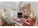 Cozy living room featuring a brick fireplace, hardwood floors, comfortable seating, and natural light at 402 Swaim Ct, Salisbury, NC 28147