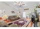 Comfortable living room featuring hardwood floors, a ceiling fan, a cozy sofa, and a brick fireplace at 402 Swaim Ct, Salisbury, NC 28147