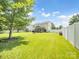Expansive backyard featuring lush green grass, a fire pit, and a charming screened-in porch at 4113 Edgeview Dr, Indian Trail, NC 28079