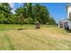 Well-maintained backyard featuring a playset, green grass, and lush trees at 433 Sinaloa St, Waxhaw, NC 28173