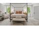 Bright bedroom featuring a four-poster bed, neutral color palette, and a comfortable seating area near the window at 433 Sinaloa St, Waxhaw, NC 28173