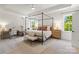Bright and airy bedroom with a four-poster bed, neutral decor, and a dedicated workspace area with a desk at 433 Sinaloa St, Waxhaw, NC 28173