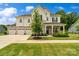 Charming two-story home with stone accents, a three-car garage, and a beautifully landscaped front yard at 433 Sinaloa St, Waxhaw, NC 28173