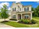 Inviting front porch with stone columns and charming rocking chairs enhance curb appeal at 433 Sinaloa St, Waxhaw, NC 28173