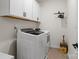 Modern laundry room with white washer/dryer, white cabinets and black hardware for extra storage at 433 Sinaloa St, Waxhaw, NC 28173