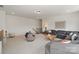 Open-concept living room with carpet flooring, gray sectional sofa, and cozy seating area at 433 Sinaloa St, Waxhaw, NC 28173