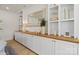 Living room shelving unit with warm wood countertop, white cabinets and shelving with stylish décor at 433 Sinaloa St, Waxhaw, NC 28173