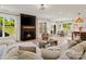 Cozy living room with a fireplace and large windows that let in natural light and connect to dining and kitchen area at 433 Sinaloa St, Waxhaw, NC 28173
