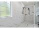 A modern bathroom with luxurious marble-look tile, rain showerhead, bench seating, and sleek fixtures for a spa-like feel at 433 Sinaloa St, Waxhaw, NC 28173
