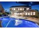 Backyard view at night showcasing the pool, outdoor dining area, and well-lit home at 4500 Carrington Dr, Lancaster, SC 29720