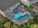 Aerial view of a backyard oasis with lush landscaping, a sparkling pool, and ample seating under colorful umbrellas at 4500 Carrington Dr, Lancaster, SC 29720