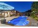 Backyard at night with pool, landscape lighting, outdoor dining, and lounge chairs at 4500 Carrington Dr, Lancaster, SC 29720