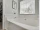 White bathtub with tile surround and window with privacy blinds at 4712 Avalon Forest Ln, Charlotte, NC 28269