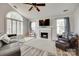 Vaulted ceiling living room features fireplace, fan, shutters, tv and wood-look floors at 4712 Avalon Forest Ln, Charlotte, NC 28269
