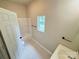 Bathroom featuring a shower/tub combo with a window, sink with cabinet at 502 E Main St, Cleveland, NC 27013