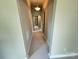 Long hallway with neutral paint and flooring and decorative hanging light at 502 E Main St, Cleveland, NC 27013