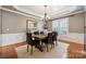 Dining room featuring paneled walls, a modern chandelier, and bright natural lighting at 5046 Cressingham Dr, Fort Mill, SC 29707