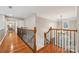 Hallway with hardwood floors and a wrought iron staircase, leading to a view of the front entrance and an upstairs bedroom at 5046 Cressingham Dr, Fort Mill, SC 29707