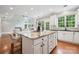 Open-concept kitchen featuring a large island with stone countertops, and barstool seating at 5046 Cressingham Dr, Fort Mill, SC 29707