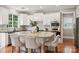 Elegant white kitchen featuring a granite island with bar seating, stainless steel appliances, and hardwood floors at 5046 Cressingham Dr, Fort Mill, SC 29707