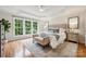 Beautiful main bedroom with a large window, hardwood floors, ceiling fan, and a tufted headboard at 5046 Cressingham Dr, Fort Mill, SC 29707