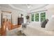Bright main bedroom featuring hardwood floors, tray ceiling, large windows, and access to other rooms at 5046 Cressingham Dr, Fort Mill, SC 29707