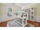 Office space with large windows, white bookshelves, and a white desk on hardwood floors at 5046 Cressingham Dr, Fort Mill, SC 29707