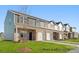 New townhomes showcase a mix of siding and brick, attached garages, and well-maintained lawns at 5142 Tommy Ln # 1202, Stanley, NC 28164