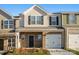 A charming townhome with a brick front, one car garage, and manicured landscaping in a modern color scheme at 5142 Tommy Ln # 1202, Stanley, NC 28164