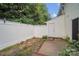 Private backyard featuring a white fence, small patio area and foliage at 5237 Ficus Tree Ln, Charlotte, NC 28215