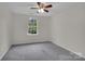 Neutral bedroom with a ceiling fan, a window and wall-to-wall carpet at 5237 Ficus Tree Ln, Charlotte, NC 28215