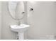 Powder room featuring pedestal sink, modern faucet, and wall mirror at 5237 Ficus Tree Ln, Charlotte, NC 28215