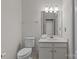 Bright, clean bathroom featuring a toilet, vanity with sink, and mirror with vanity lighting at 5305 Waverly Lynn Ln # 4A, Charlotte, NC 28269