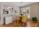 Bright dining area with a glass table, yellow chairs, and a view into the kitchen at 5305 Waverly Lynn Ln # 4A, Charlotte, NC 28269
