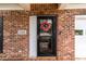 Close-up of a front door with a colorful wreath, address number, and classic brick surround at 5305 Waverly Lynn Ln # 4A, Charlotte, NC 28269