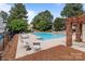 A pristine community pool with lounge chairs for relaxation, surrounded by shade trees at 5305 Waverly Lynn Ln # 4A, Charlotte, NC 28269