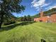 Expansive backyard with mature trees bordering the property and an attached brick house at 5420 Harkey Rd, Waxhaw, NC 28173