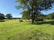 Sprawling green lawn enhanced by lush trees and distant water views at 5420 Harkey Rd, Waxhaw, NC 28173