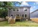 View of the back of the home featuring a wooden deck with stairs leading to the lawn at 550 W Cama St, Charlotte, NC 28217