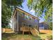 The rear exterior view showcases a two-story home with a deck, enhanced by surrounding trees at 550 W Cama St, Charlotte, NC 28217