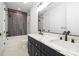 Bathroom featuring a dual vanity with black cabinets and a tiled shower/tub at 550 W Cama St, Charlotte, NC 28217