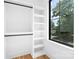 Neat closet with window, built-in shelving, and black rods for hanging clothes at 550 W Cama St, Charlotte, NC 28217