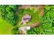 Aerial view of a property nestled in a forest, surrounded by lush greenery and open space at 6350 Mount Pleasant S Rd, Concord, NC 28025