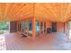 View of the covered deck showcasing a brick accent wall, wooden ceiling, and multiple access points at 6350 Mount Pleasant S Rd, Concord, NC 28025