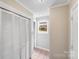 Hallway featuring closet doors, neutral paint color, and a window at 6350 Mount Pleasant S Rd, Concord, NC 28025