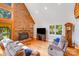 Bright living room features a brick fireplace, hardwood floors, and large windows at 6350 Mount Pleasant S Rd, Concord, NC 28025