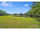 Expansive green lawn leading to a picturesque pond, enhancing the property's natural beauty at 6350 Mount Pleasant S Rd, Concord, NC 28025